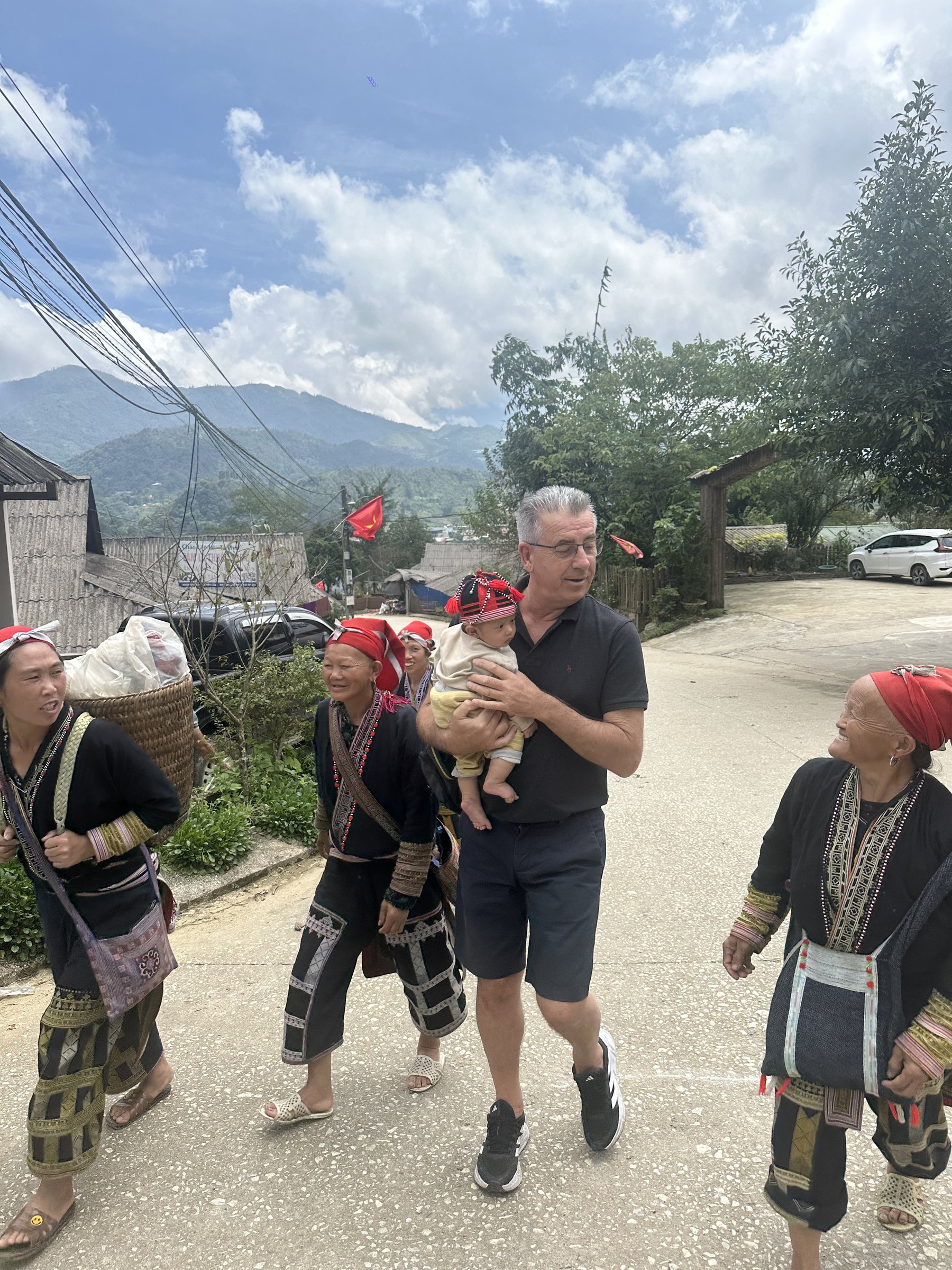 Christophe Goisset walking with members of a partner community during a field visit in Vietnam