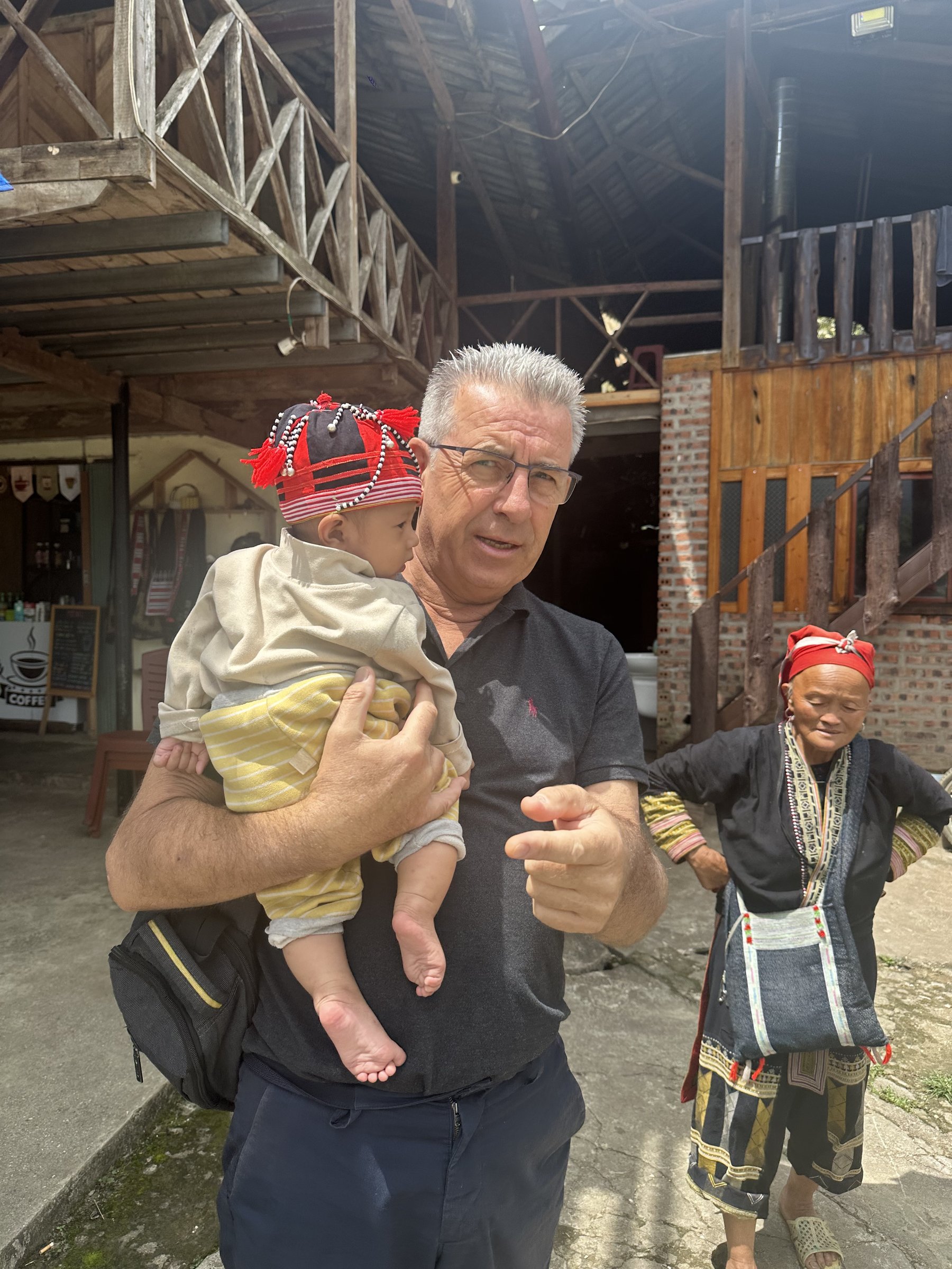 Christophe Goisset holding a child during a visit to a partner community in northern Vietnam